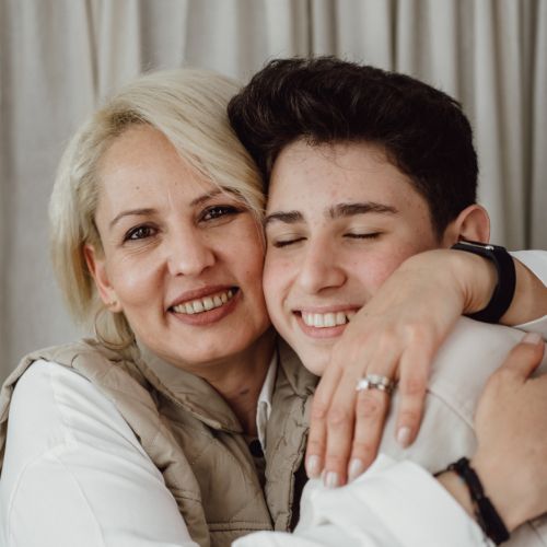 Happy Mom and Teen Son Embracing Each Other