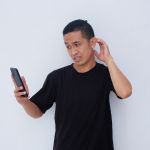 Man Holding Phone with Confuse Gesture