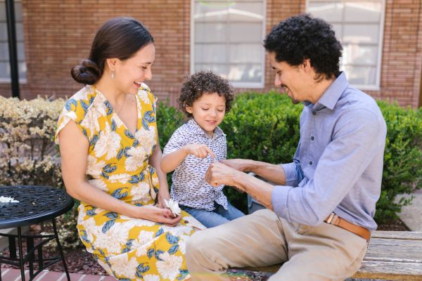 Parents Playing with their Child while Sitting on the Bench