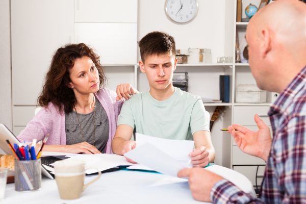 Parents with teenager son reading documents
